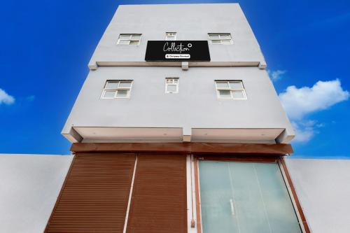 a tall white building with a sign on it at Collection O Sector 33 Gurgaon in Gurgaon