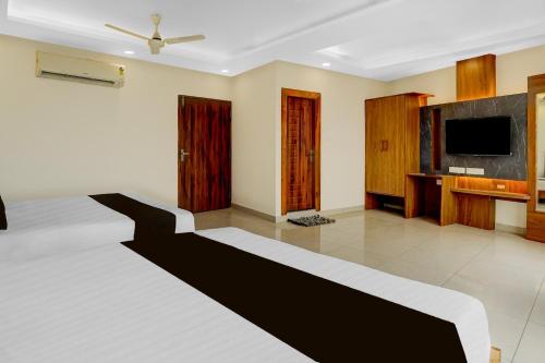 a living room with a bed and a flat screen tv at Super Townhouse Varanasi City Station Formerly S Kumar Inn in Varanasi