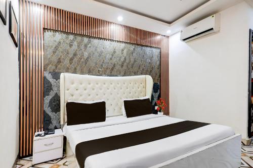 a bedroom with a large white bed and a wall at Super Townhouse ESIC Medical College Faridabad Formerly Royal Mountain in Faridabad