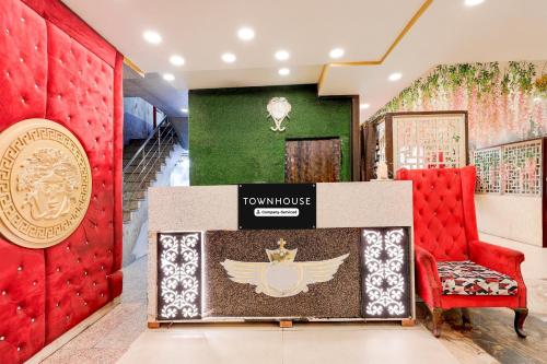a room with a red chair and a sign on the wall at Super Townhouse ESIC Medical College Faridabad Formerly Royal Mountain in Faridabad