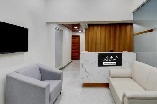 um átrio com duas cadeiras, uma mesa e uma televisão em Super Hotel O Pune Kasarwadi Railway Station em Pune