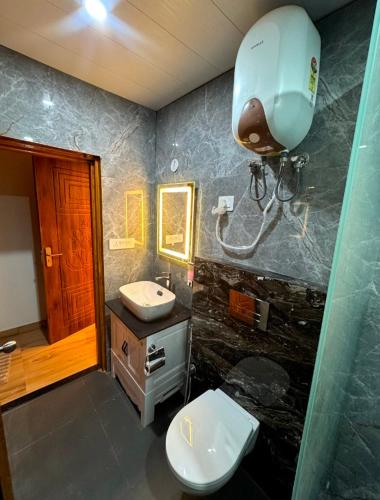 a bathroom with a white toilet and a sink at Varlaxmi Vatika in Rānīkhet