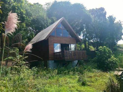 a small house with a deck in a field at Cabana Gehrke in Nova Petrópolis