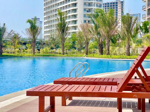 a wooden bench sitting next to a swimming pool at Pool & Gym Condo - Free laundry - 400m to beach in Sihanoukville