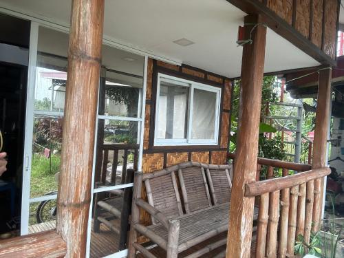 a porch with a wooden chair on a house at TeamV Kubo Guesthouse in Agdañgan