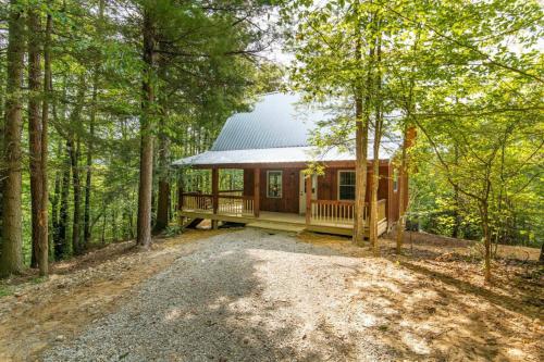 a log cabin in the woods with a gravel driveway at Pet-Friendly Tiny Cabin - Pine Point in Pine Ridge