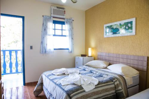 une chambre avec un lit et une fenêtre dans l'établissement Pousada Recanto Sol a Sol, à Cabo Frio