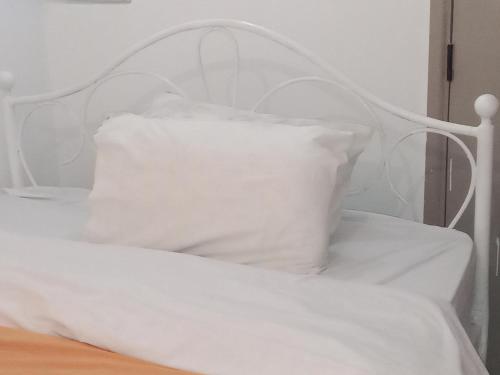a white bed with a white pillow on it at CK place in Nairobi