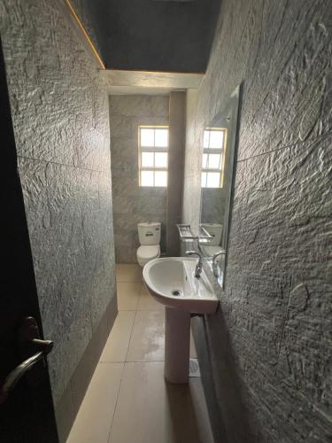 a bathroom with a sink and a toilet at Savannah Residence in Libwezi