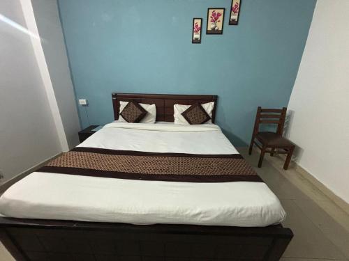 1 dormitorio con 1 cama con cabecero de madera y silla en Hotel R Villa - Near Hauz Khas Fort, en Nueva Delhi