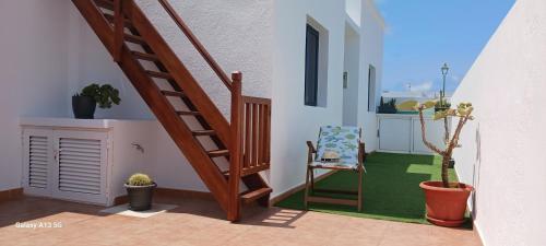 a room with a staircase and a chair and a plant at Casa Mar Azul. in Tinajo