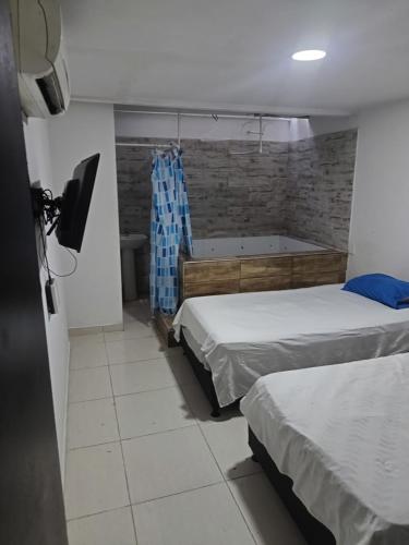 a bedroom with two beds and a bath tub at 2 habitaciónes 3 baños in Cúcuta