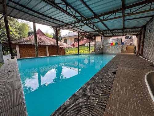 une grande piscine avec de l'eau bleue dans un immeuble dans l'établissement Villa Bukit Punclut, à Bandung