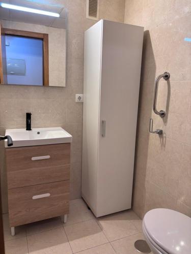 a bathroom with a sink and a white refrigerator at Beach Apartament Playa in El Campello
