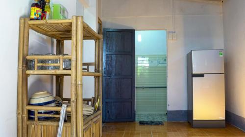 a kitchen with a ladder next to a refrigerator at Homestay Nhà Của Gạo in Ấp Thiẹn Ái