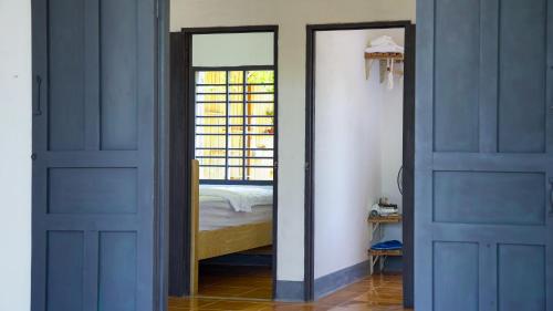 a bedroom with blue doors and a bed in a room at Homestay Nhà Của Gạo in Ấp Thiẹn Ái