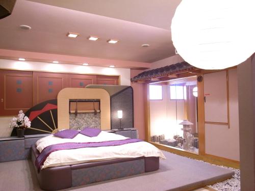 a bedroom with a large bed in a room at ホテル うさぎ -岡山運転免許センター南- 