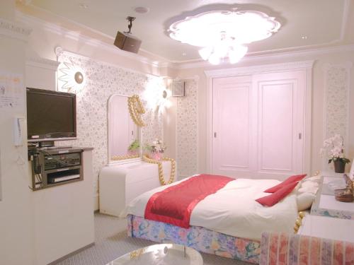 a bedroom with a large bed and a television at ホテル うさぎ -岡山運転免許センター南- 