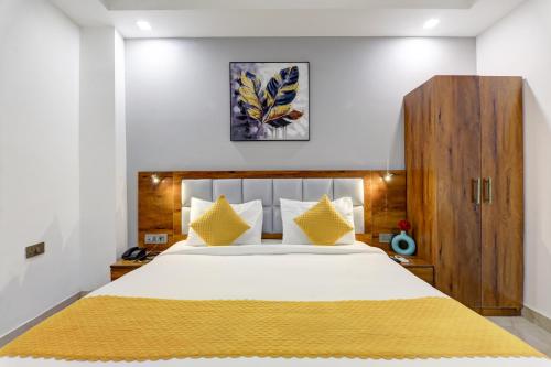 a bedroom with a large white bed with yellow pillows at Hotel Travana Stay at Pitampura in New Delhi