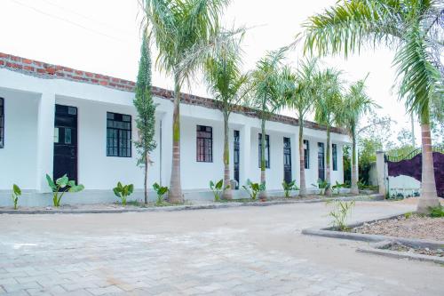 a building with palm trees in front of a street at Lake View Suites, Homa Bay in Homa Bay