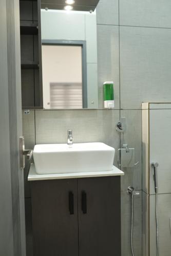 a bathroom with a white sink and a shower at Venetus Beach Residence in Varkala