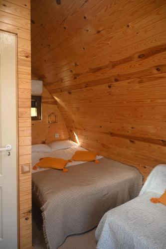 アヴリグにあるCăsuțe în mijlocul naturii - Wild Camp Avrigの木造の部屋にベッドが2つある寝室