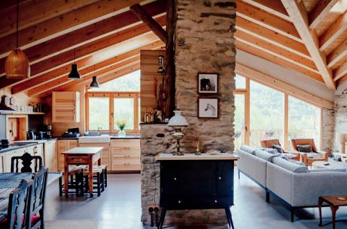 cocina y sala de estar con pared de piedra en Espectacular Chalet de Montaña Pirineos, Burg, en Burg