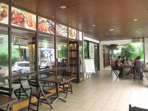 a restaurant with tables and chairs and people sitting at tables at Dusit Hotel in Sakon Nakhon