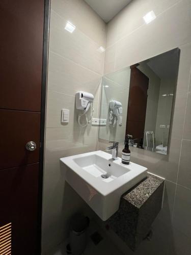 a bathroom with a white sink and a mirror at 1BR - Uptown BGC Taguig in Manila