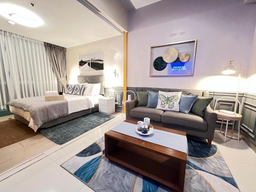 a living room with a bed and a couch at 1BR - Uptown BGC Taguig in Manila