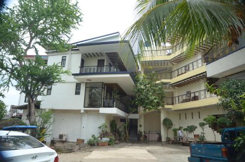 een gebouw met balkons en een auto voor het gebouw geparkeerd bij Reyna's the Haven & Gardens in Tagbilaran-stad
