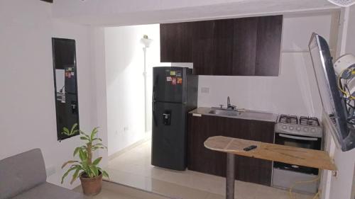 ククタにあるApartaestudio Con Amplio Parqueaderoの黒い冷蔵庫とシンクのあるキッチン