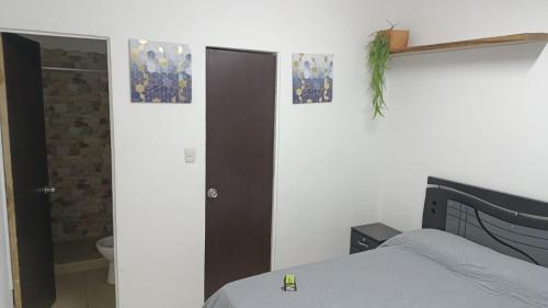 ククタにあるApartaestudio Con Amplio Parqueaderoのベッドルーム1室(ベッド1台、ドア、バスルーム付)