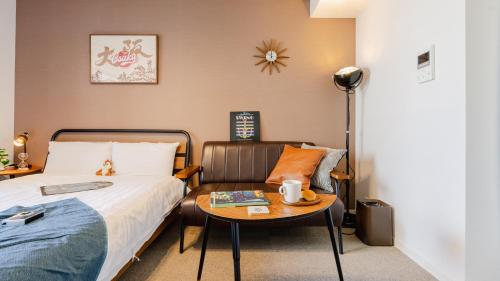 a bedroom with a bed and a table with a chair at 川HOUSE黒門 in Osaka