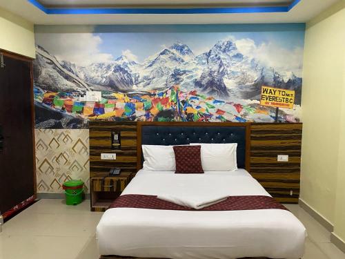 une chambre avec un grand lit avec un tableau au mur dans l'établissement Hotel Sun Star International Pvt Ltd, à Siddharthanagar