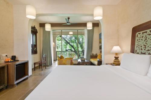 Un dormitorio con una cama grande y una sala de estar. en Riva Beach Resort, en Mandrem