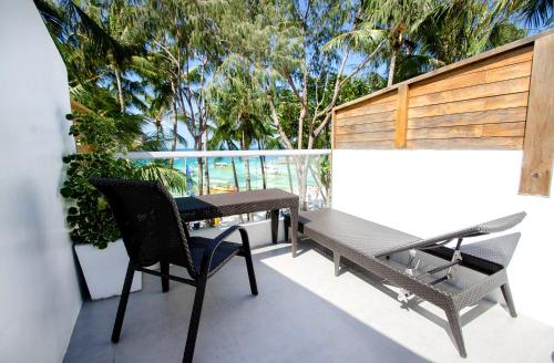 a balcony with a table and chairs and trees at Zuzuni Boutique Hotel in Boracay