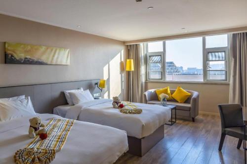 a hotel room with two beds and a couch at Yitel Tai'an Taishan Hongmen Daimiao in Tai'an