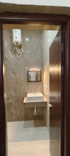 a bathroom with a sink and a large mirror at THE FARM CREST, ECR KADALLUR in Kūvattūr