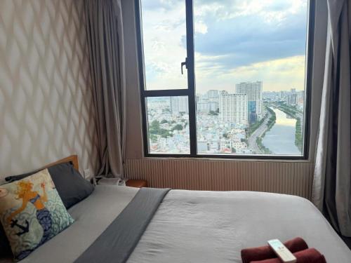 una camera da letto con un letto e una grande finestra di Stay With Me CBD Apartment - Rivergate Building ad Ho Chi Minh