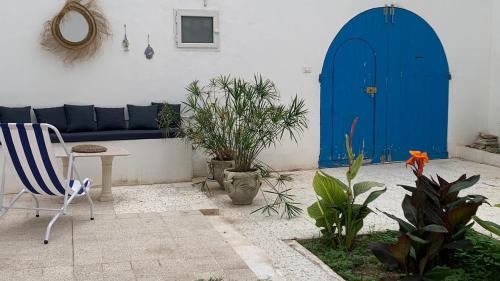 a living room with a blue couch and a blue door at Petite maison typique à 2 pas de la mer in Sousse