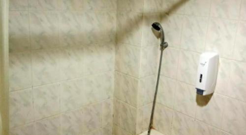 a shower with a hair dryer attached to a wall at Puri Mega Hotel in Jakarta