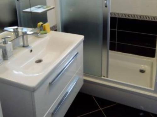 a white bathroom with a sink and a shower at Two-Bedroom Apartment With Terrace in Sreser