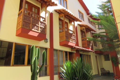 a building with windows and a cactus in front of it at Hospedaje Kamila in Cusco