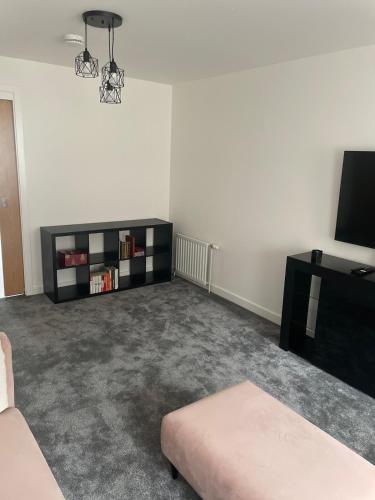 a living room with a couch and a tv at Maison 109 Suite - Modern City Apartment in Glasgow