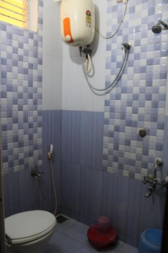 a bathroom with a toilet and a shower at Arunachala Residency in Tiruvannāmalai