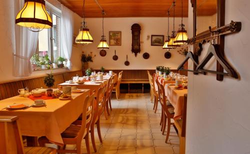 Hotel Feuerbacher Hof في شتوتغارت: غرفة طعام مع طاولات وكراسي وأضواء