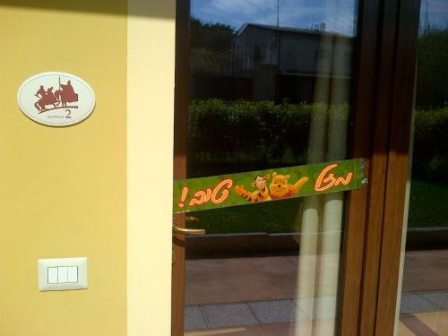 a glass door with a sign on it with a dog sticker at Corte Attilea in Valeggio sul Mincio