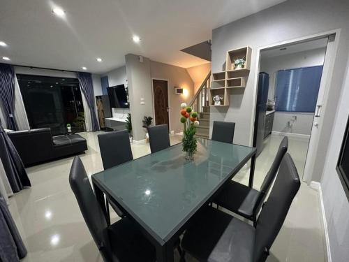 comedor y sala de estar con mesa de cristal y sillas en บ้านเดี่ยวหางดง ย่านมหาวิทยาลัยนอร์ทเชียงใหม่, en Ban Phae Buak Ha