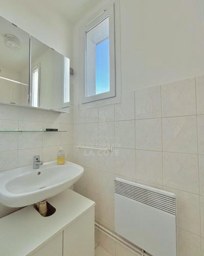 a white bathroom with a sink and a mirror at Le Refuge du Port in Étaples